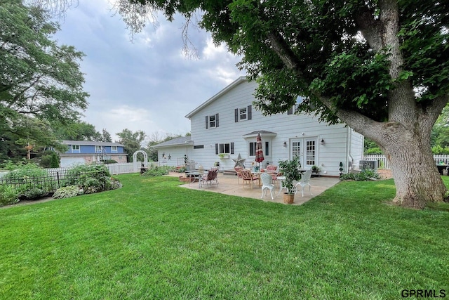 rear view of house with a patio and a lawn