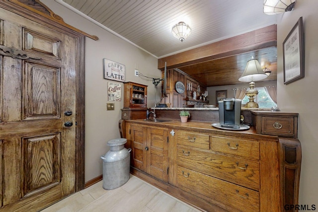 kitchen with wooden ceiling, light tile patterned floors, and sink