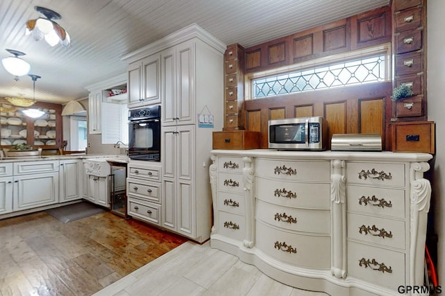 kitchen featuring kitchen peninsula, light hardwood / wood-style floors, white cabinetry, and oven