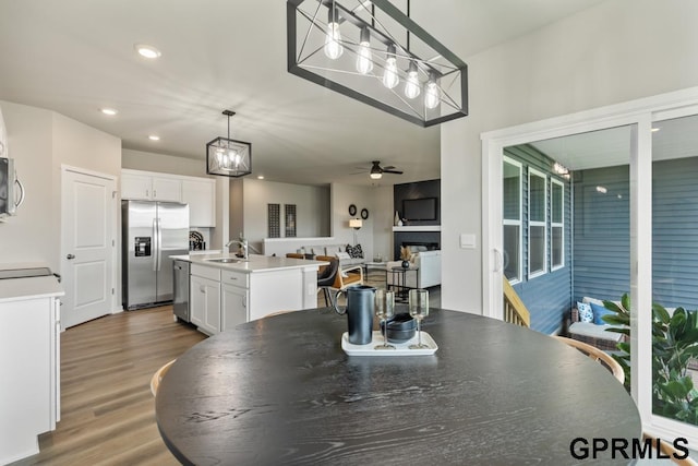 dining room with ceiling fan, sink, and wood-type flooring