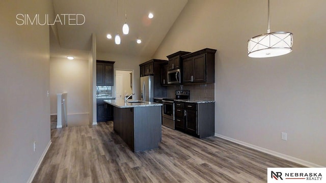 kitchen with dark brown cabinetry, hanging light fixtures, stainless steel appliances, and light stone countertops