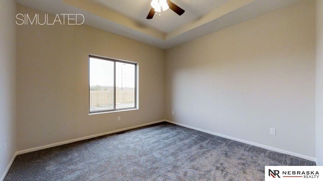 unfurnished room with a raised ceiling, carpet flooring, and ceiling fan