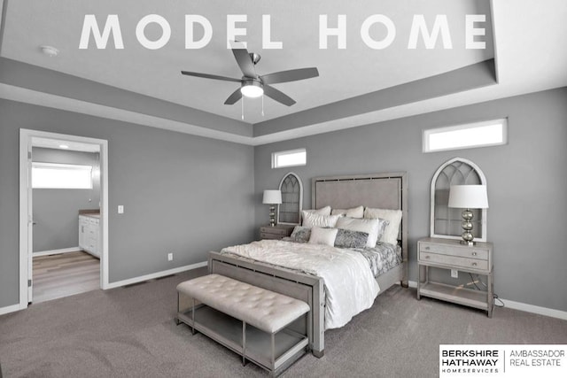 bedroom featuring multiple windows, a tray ceiling, and carpet floors