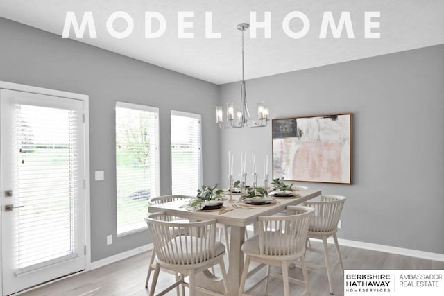 dining area with light hardwood / wood-style floors and a notable chandelier