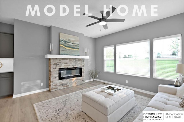 living room with ceiling fan, a fireplace, and light wood-type flooring