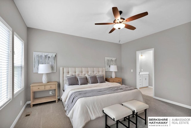 bedroom featuring ensuite bathroom, ceiling fan, and light carpet