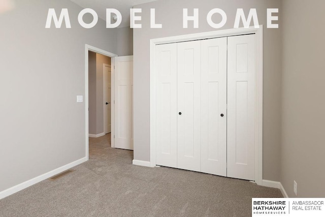 unfurnished bedroom featuring light carpet and a closet