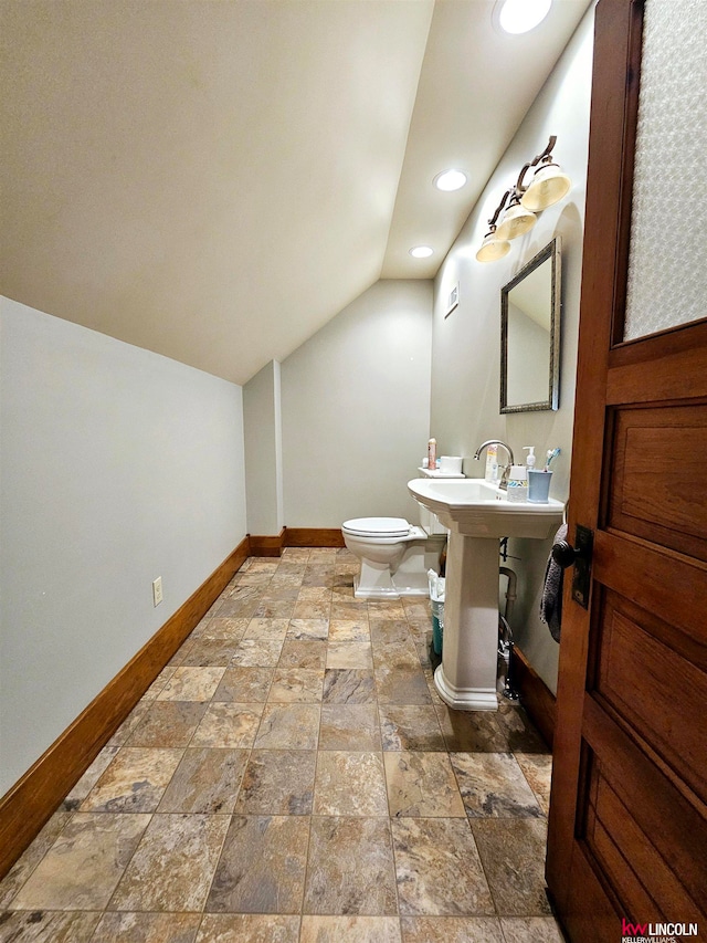 bathroom with tile patterned floors, vaulted ceiling, and toilet