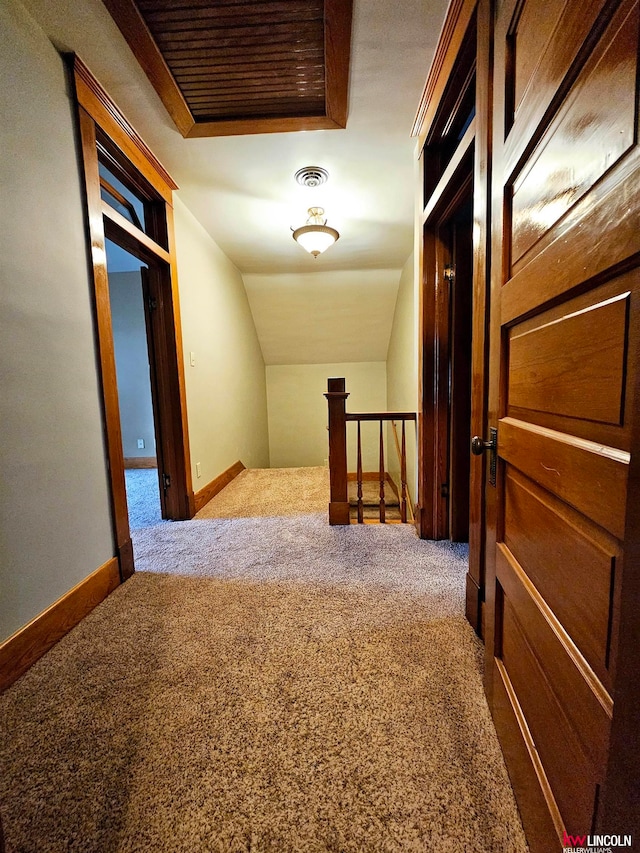 hallway with lofted ceiling and carpet flooring