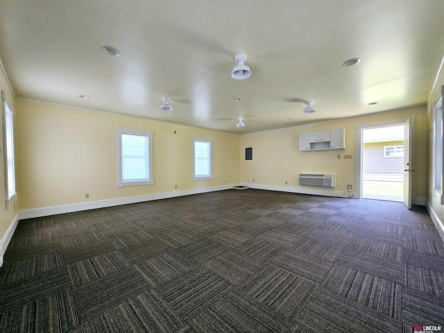 empty room featuring a wall mounted AC and dark carpet