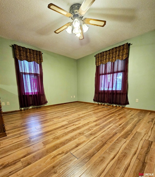 unfurnished room with a textured ceiling, ceiling fan, and light hardwood / wood-style floors