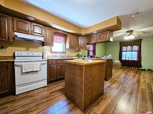 kitchen featuring a textured ceiling, extractor fan, hardwood / wood-style flooring, ceiling fan, and white electric range