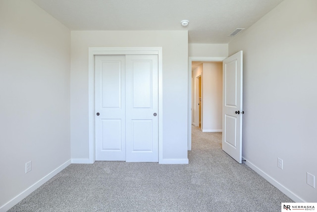 unfurnished bedroom with carpet flooring and a closet