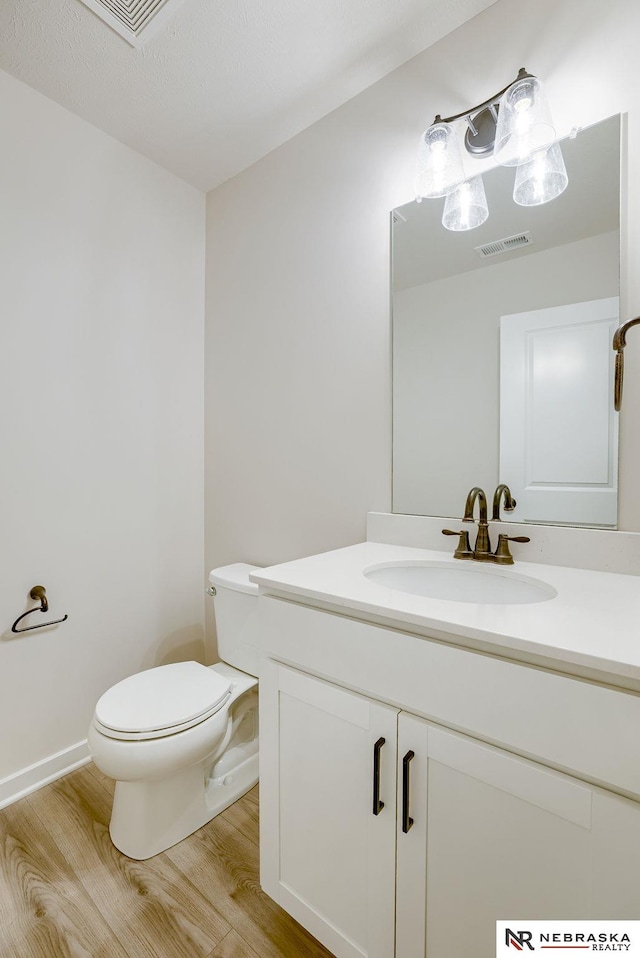 bathroom featuring vanity, toilet, and hardwood / wood-style floors