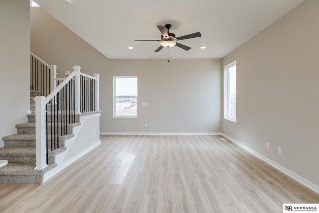 interior space with a towering ceiling and light hardwood / wood-style flooring