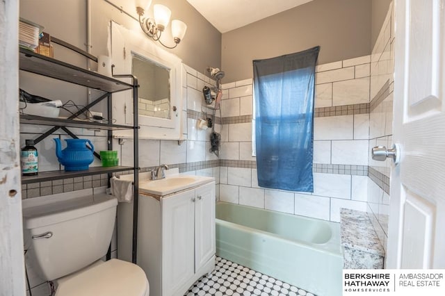 full bathroom featuring tile walls, toilet, tile patterned floors, vanity, and tiled shower / bath combo