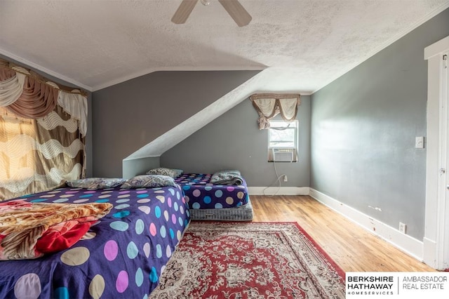 bedroom featuring lofted ceiling, a textured ceiling, ceiling fan, light hardwood / wood-style floors, and cooling unit