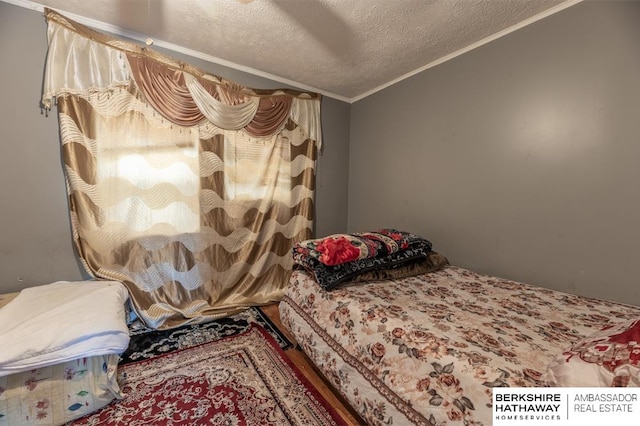 bedroom featuring a textured ceiling, ornamental molding, and ceiling fan