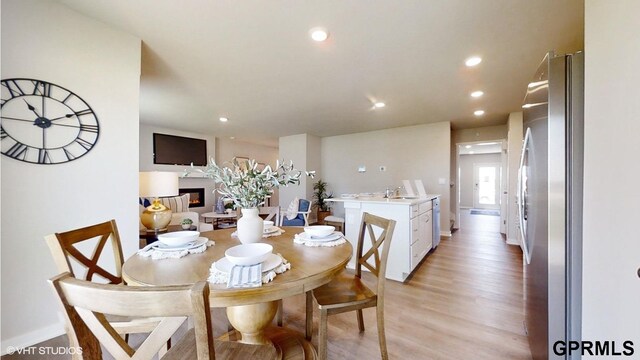 dining room with light hardwood / wood-style flooring and sink