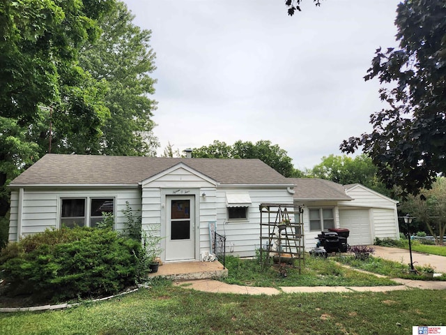 ranch-style home with a garage and a front lawn