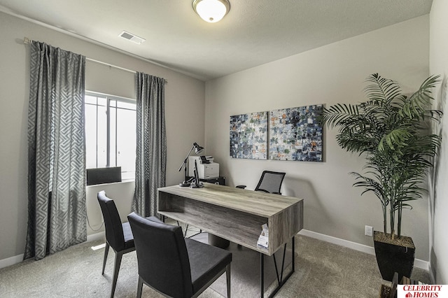 carpeted office space with baseboards and visible vents