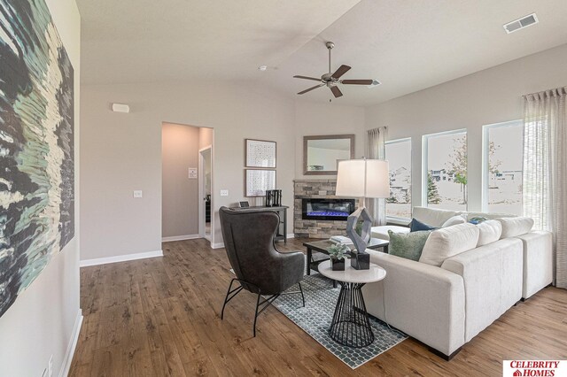 living room with ceiling fan, wood-type flooring, a fireplace, and lofted ceiling