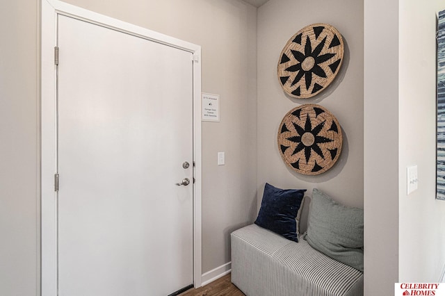 doorway with baseboards and wood finished floors