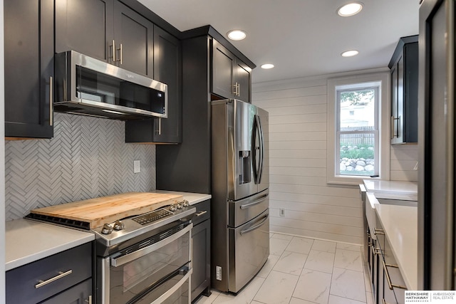 kitchen featuring stainless steel appliances, decorative backsplash, and light tile patterned floors