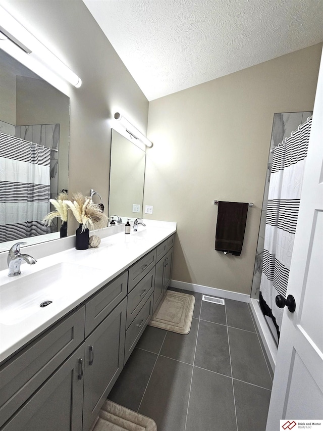 bathroom featuring tile patterned flooring, vanity, curtained shower, and a textured ceiling