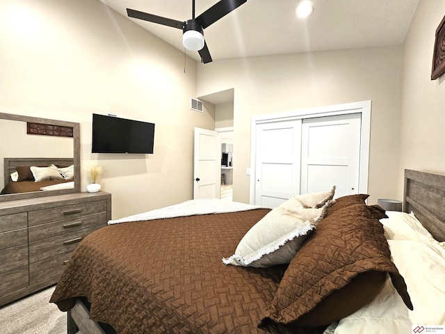 carpeted bedroom with vaulted ceiling, a closet, and ceiling fan