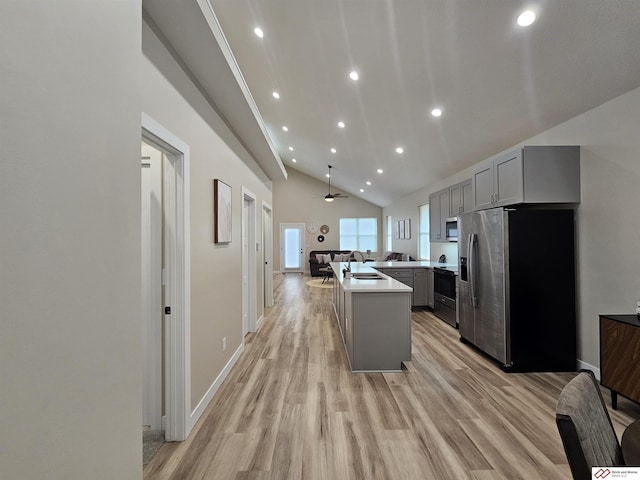 kitchen with sink, gray cabinetry, a center island, stainless steel appliances, and light hardwood / wood-style flooring