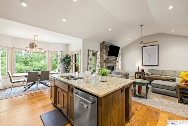 kitchen featuring sink, light wood-type flooring, decorative light fixtures, and dishwasher