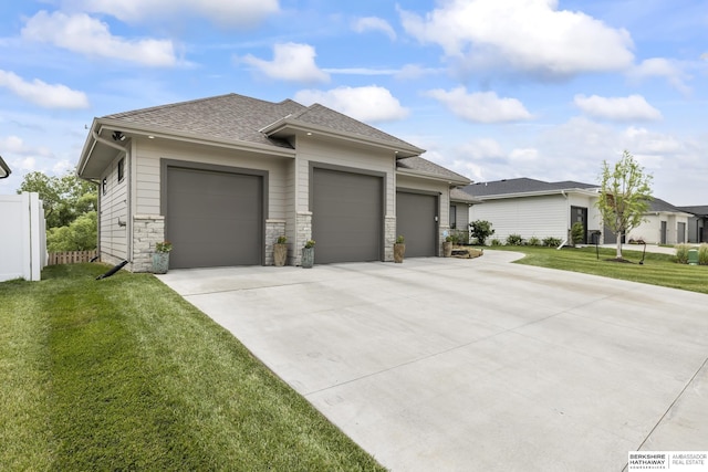 prairie-style house featuring a garage and a front lawn