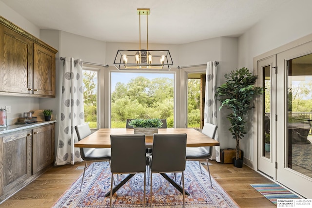 dining area featuring a notable chandelier and light wood-type flooring