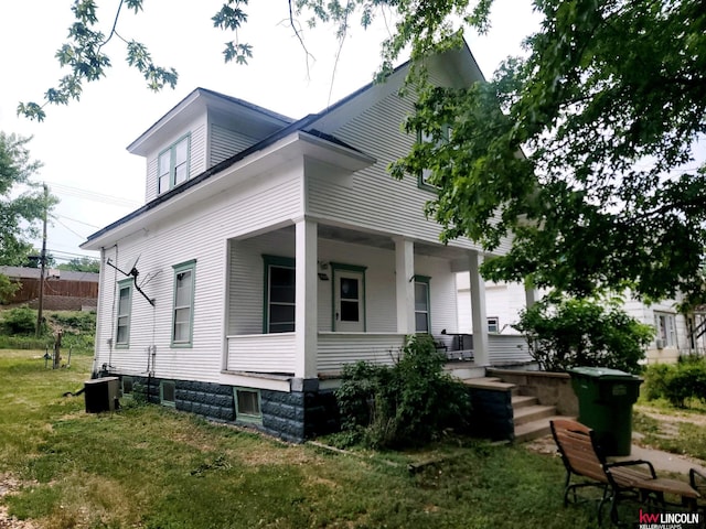 back of house featuring a lawn and a porch