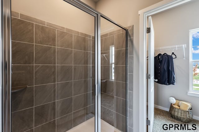 bathroom with a stall shower and baseboards