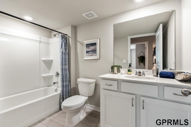 bathroom with visible vents, toilet, shower / bath combo, vanity, and wood finished floors