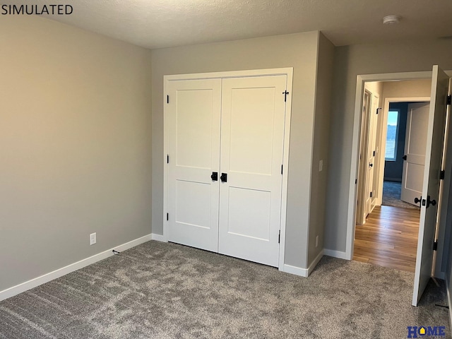 unfurnished bedroom with carpet, a closet, and a textured ceiling