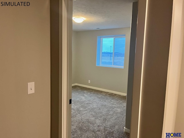 corridor featuring a textured ceiling and carpet