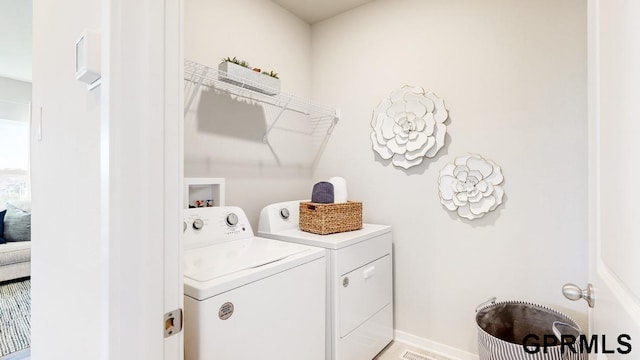 clothes washing area with separate washer and dryer