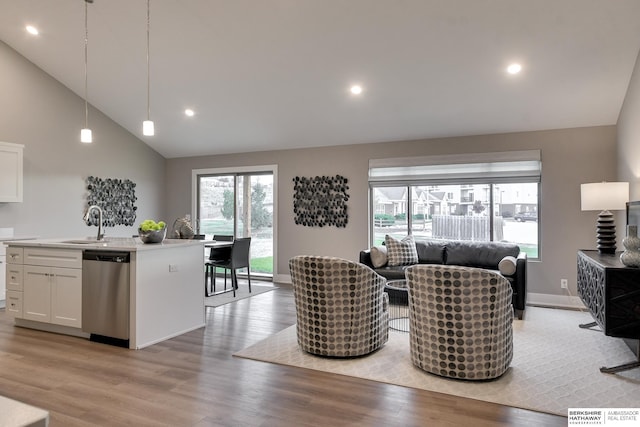 living area with high vaulted ceiling, light wood-style flooring, baseboards, and recessed lighting