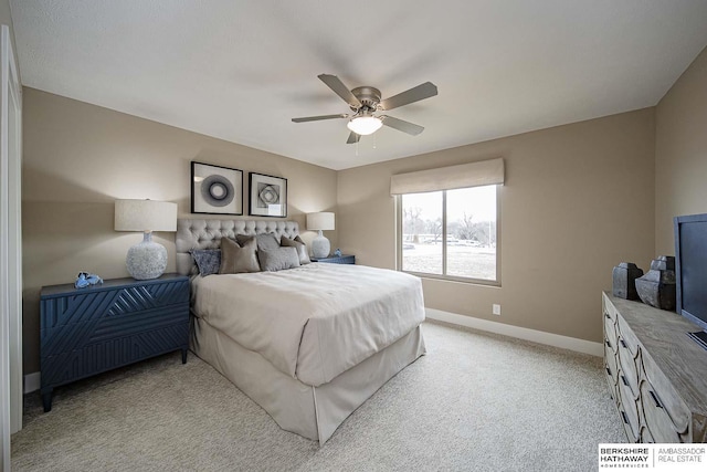 bedroom with ceiling fan, baseboards, and light colored carpet