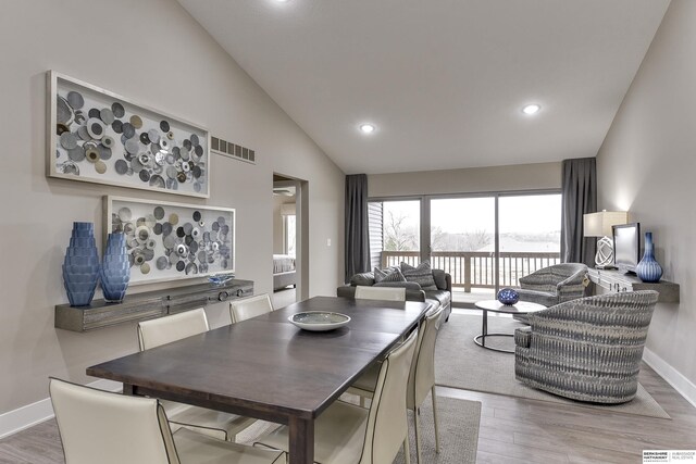 living room with light hardwood / wood-style floors, vaulted ceiling, and sink