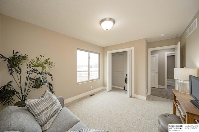 sitting room with light carpet, visible vents, and baseboards