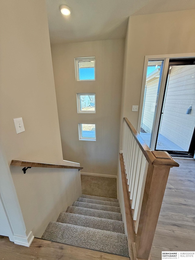 staircase with baseboards and wood finished floors