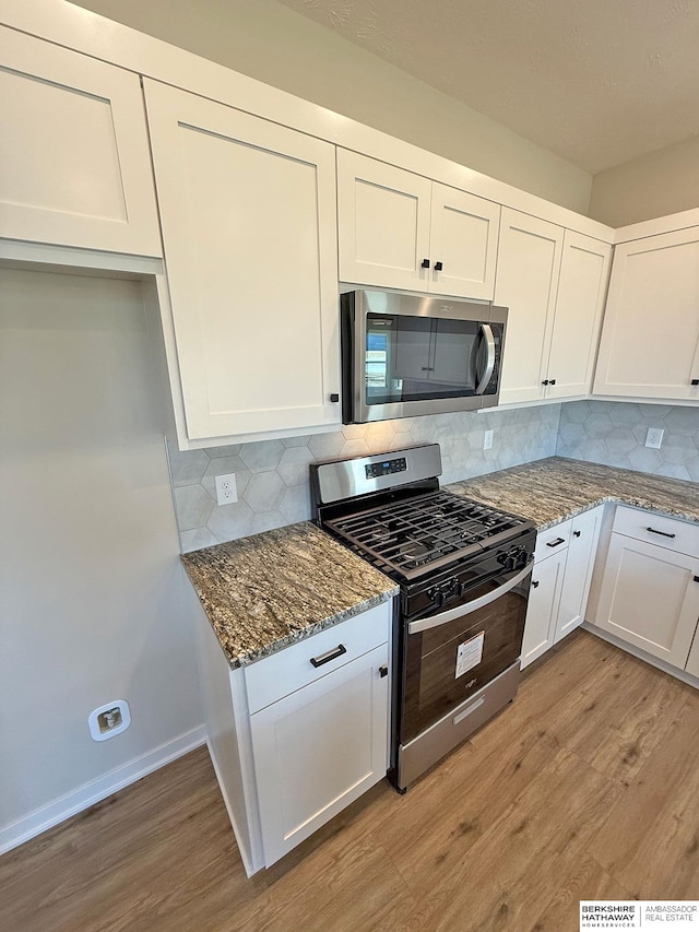 kitchen featuring white cabinets, light wood-style flooring, and stainless steel appliances