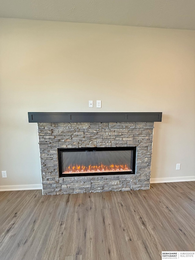 details with a fireplace, baseboards, and wood finished floors