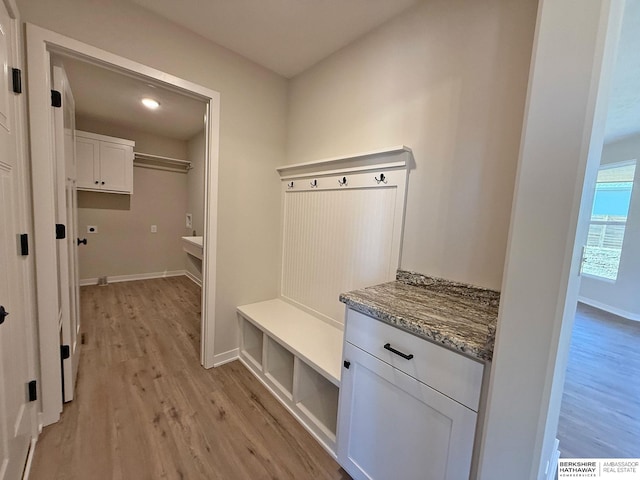 mudroom featuring baseboards and light wood finished floors