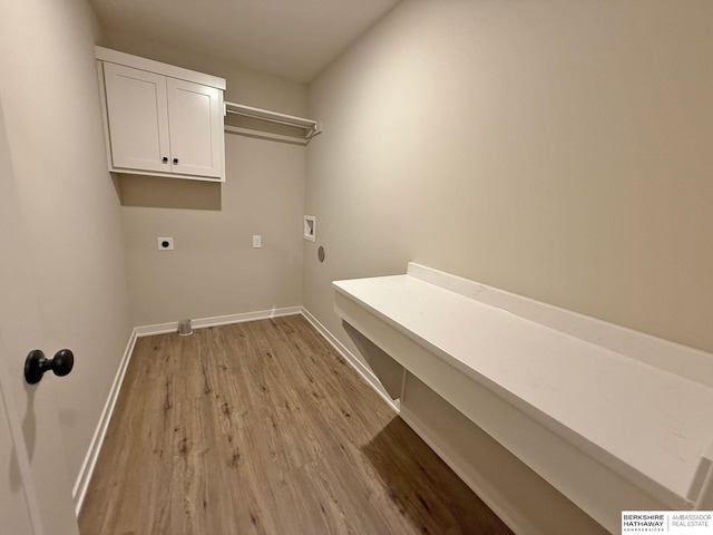 washroom with cabinet space, light wood-style floors, baseboards, and hookup for an electric dryer