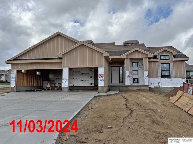 view of front of property featuring driveway, board and batten siding, and an attached garage